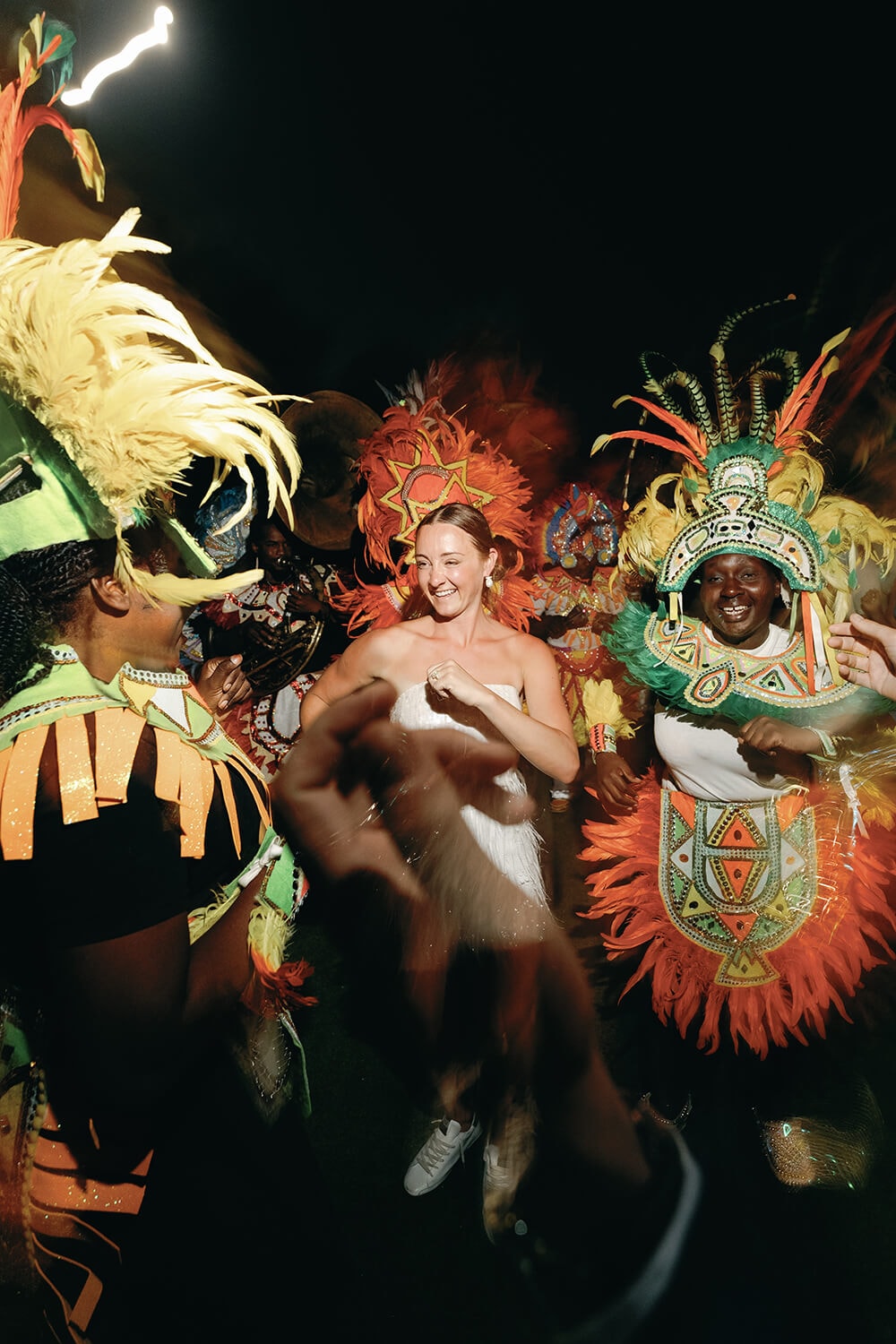 Vibrant dancers in colorful costumes perform at a destination wedding celebration.